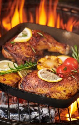 grilled-chicken-legs-flaming-grill-with-grilled-vegetables-with-tomatoes-potatoes-pepper-seeds-salt_1150-37781
